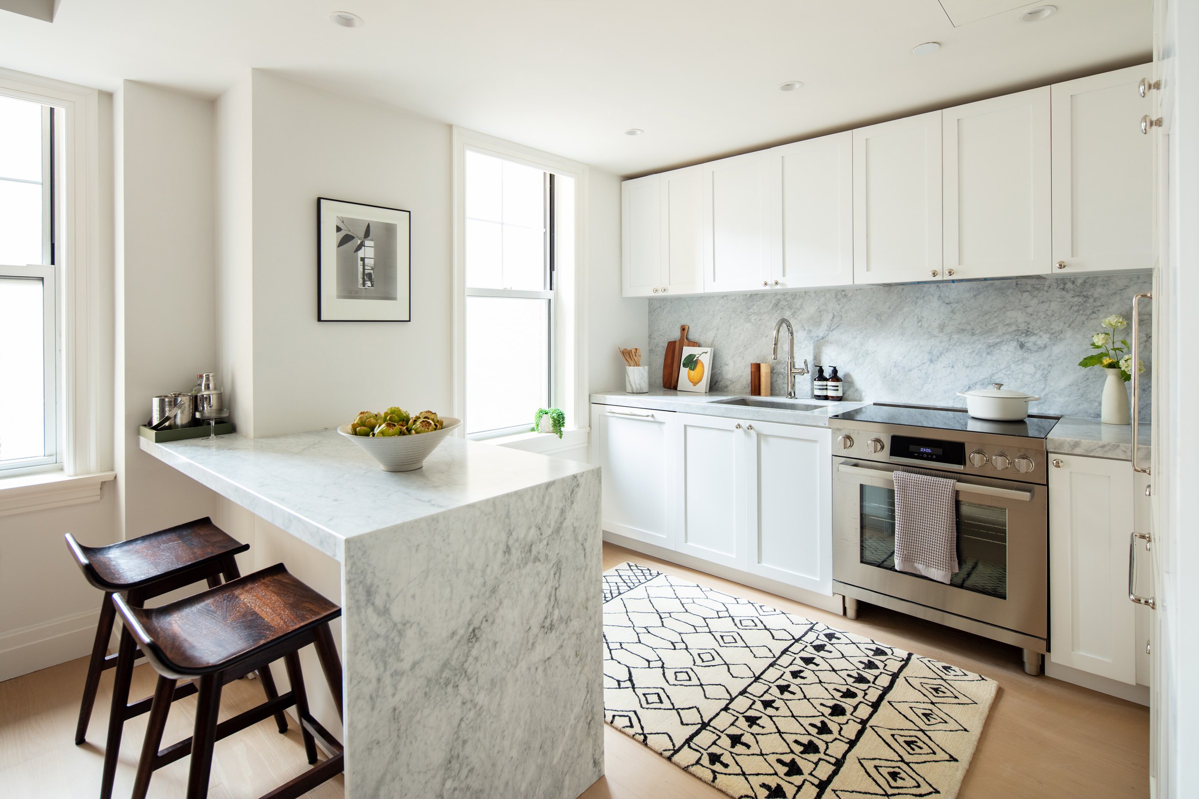 Kitchen in honed Bianco Carrara marble with custom millwork