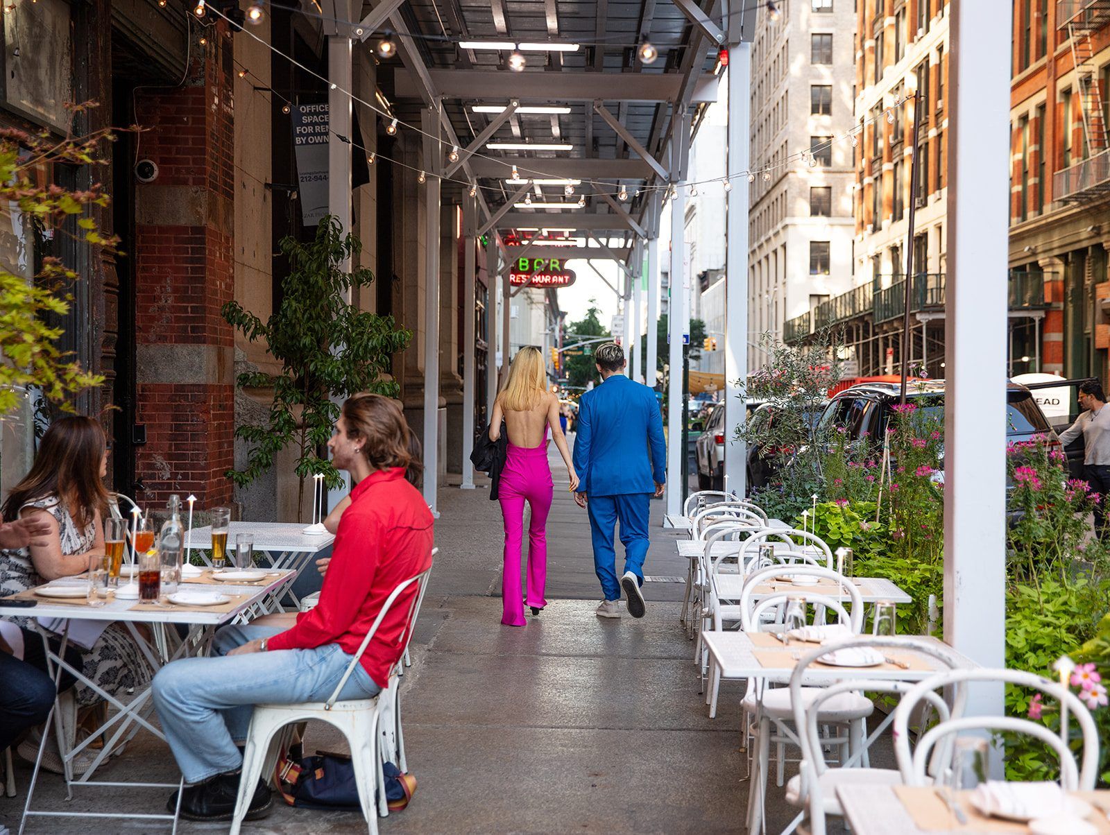 Sidewalk tables and string lights on a summer evening